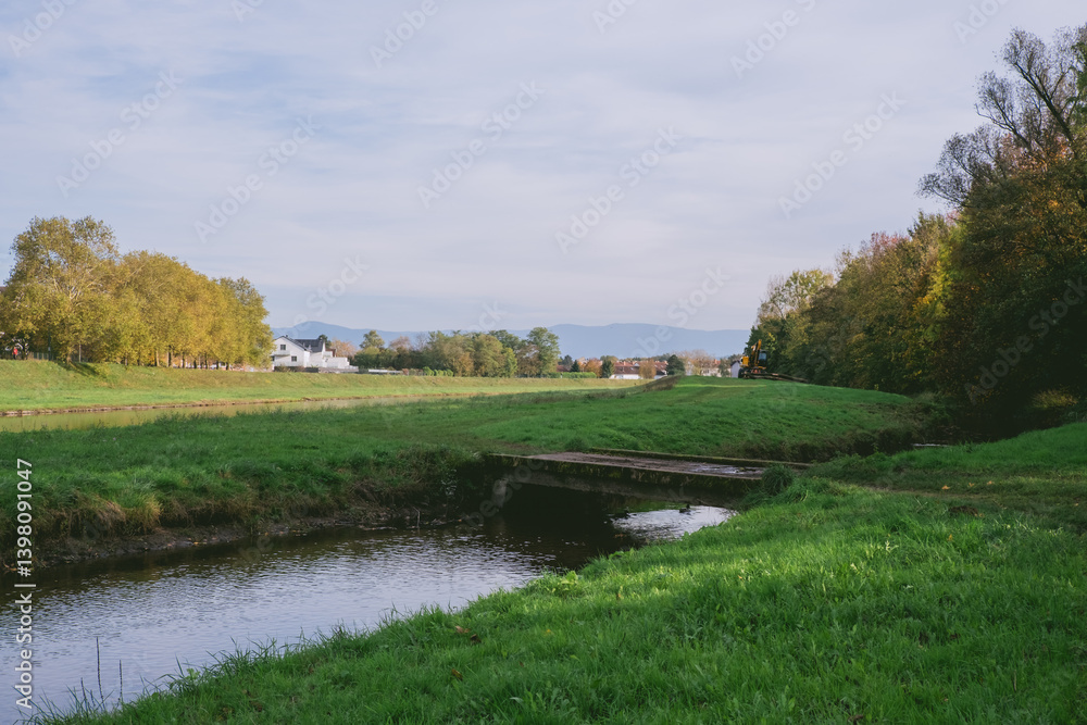 Poster grassy field with a small stream running through it