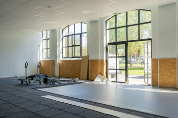 Salle de classe en cours de rénovation dans une école, avec matériel de chantier et murs...