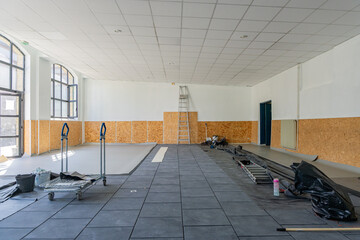 Salle de classe en cours de rénovation dans une école, avec matériel de chantier et murs partiellement refaits. © Thomas