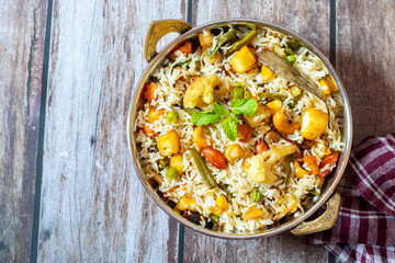 Navratan Pulao is a fragrant, colorful rice dish cooked with mixed vegetables, dry fruits, and aromatic spices, often served warm.
