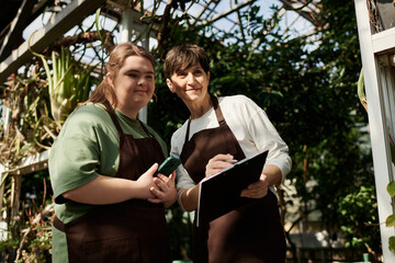 Collaboration in a greenhouse between a mature woman and her young colleague with Down syndrome