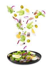 Delicious herring salad isolated on white. Fresh ingredients flying over plate