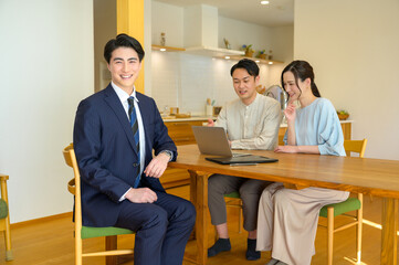 パソコンを使って説明をする日本人のビジネスマン