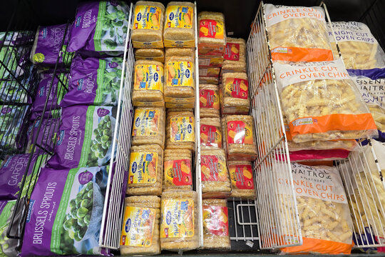 Bangsar, Malaysia &ndash; Mar 29, 2025: Packs of frozen hash browns, crinkle cut oven chips, and Brussels sprouts arranged neatly in a supermarket freezer section.