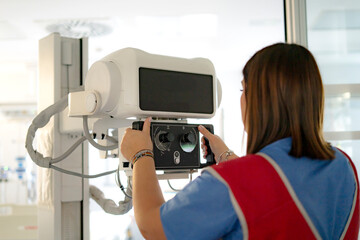 Naklejka premium Female radiologist preparing x-ray machine in hospital room