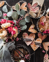 flat-lay still life of mixed-media hearts strung together with twine and flowers