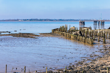 A pier over the river thames viewed from the Cliffe RSPB nature reserve near Gravesend in Kent, England