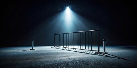 Nighttime scene of a metal barrier under a single bright light source on a dark asphalt surface with two bollards