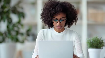A businesswoman analyzing asset management trend reports on a laptop, developing strategies based on future forecasts