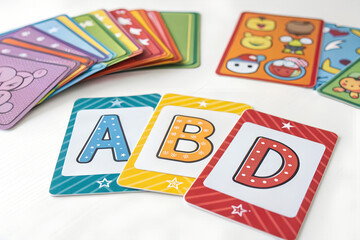 Colorful flashcards with bold letters spread on white background, learning fun
