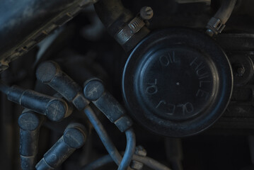Close-up view of the cover of a mechanical part for oil refilling and a spark plug
