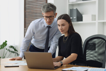 Coworkers working together at table in office