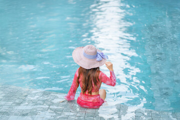 Beautiful Asain women with bikini enjoy summer vacation in the swimming pool.	