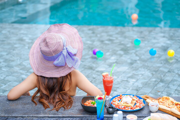Beautiful Asain women with bikini enjoy summer vacation in the swimming pool.	