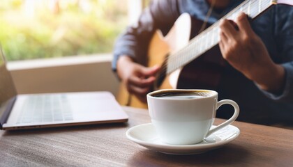 A cup of coffee and hands playing a guitar