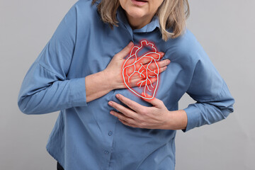 Senior woman suffering from heart attack on grey background, closeup. Illustration of heart on chest