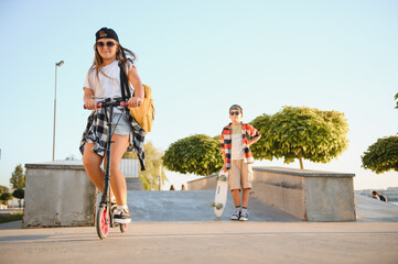 Obraz premium Dressed in stylish clothes, a boy and a girl at the skate park