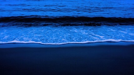 Fototapeta premium The blue ocean waves softly crashing onto the sandy shore