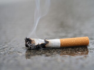 A close-up of an extinguished cigarette resting on a textured surface, showcasing the ash and burnt paper, symbolizing the end of a habit.