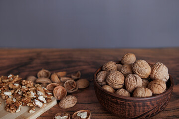 nuts in a clay bowl on a table with a wooden board