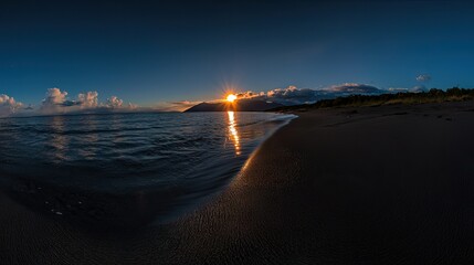 Obraz premium Beautiful sun setting over ocean water and dark sand