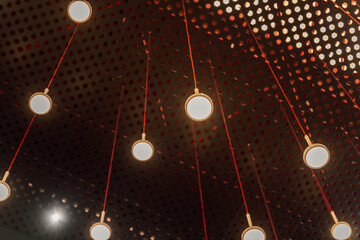 eco lamps in the exhibition hall. round lamps on the background of perforated aluminum