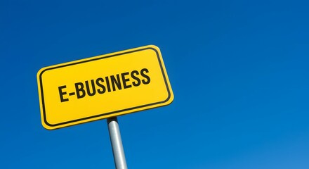 Fototapeta premium Bright Yellow Road Sign Displaying E-Business Message Against Clear Blue Sky.