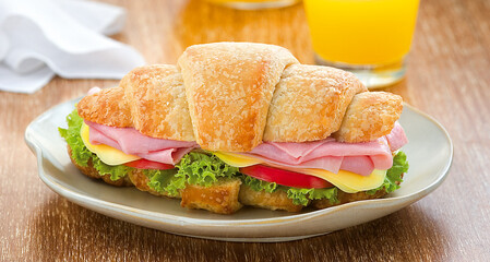 delicioso croissant com presunto, queijo, tomate e alface