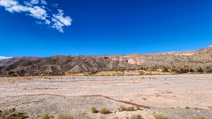 ERODED HILLS AND DRY RIVERBED IN THE QUEBRADA DE HUMAHUACA, ARGENTINA..