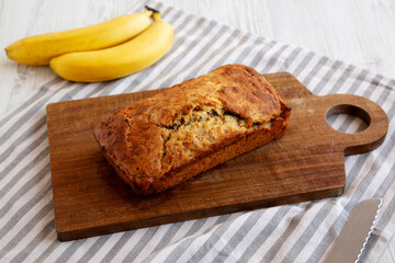 Homemade Banana Bread on a wooden board, side view.