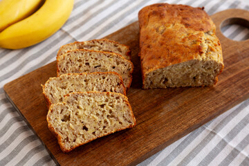 Homemade Banana Bread on a wooden board, side view.