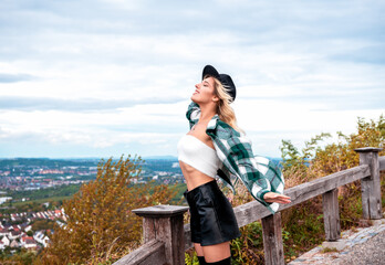Smiling woman standing in the wind on a hilltop in Stuttgart City, Germany