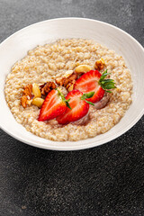 Oatmeal porridge strawberries nuts healthy breakfast appetizer dish fresh delicious gourmet food background on the table rustic food top view copy space keto and paleo diet vegetarian and vegan food