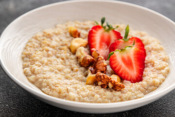 Oatmeal porridge strawberries nuts healthy breakfast appetizer dish fresh delicious gourmet food background on the table rustic food top view copy space keto and paleo diet vegetarian and vegan food