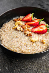 Oatmeal porridge strawberries nuts healthy breakfast appetizer dish fresh delicious gourmet food background on the table rustic food top view copy space keto and paleo diet vegetarian and vegan food