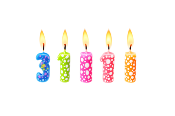 Colorful birthday candles with different patterns and lit flames arranged in a row on a white background