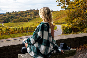 Tourist woman enjoys the panoramic view over an autumn vineyard in Stuttgart, Germany