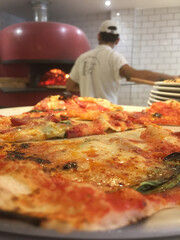 Pizzero haciendo una pizza en una pizzería