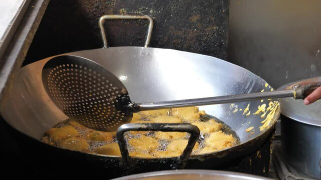 Vada being fried slowly in oil in Mumbai, Maharashtra, India
