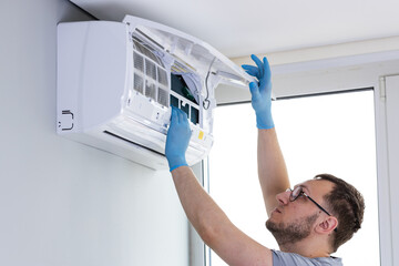 Professional Service: An Expert Technically Skilled Individual Reaches Up to Perform Maintenance on...