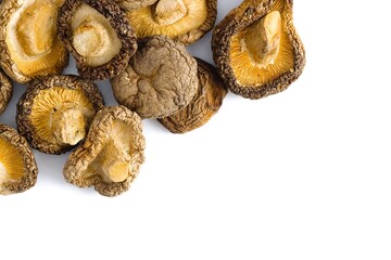 A close-up of dried shiitake mushrooms on white, highlighting their intricate, rustic textures and natural hues.