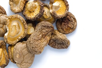 A crisp image of dried shiitake mushrooms on white, highlighting their rustic texture and earthy, natural tones.