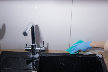Cleaning Activities in the Kitchen: Scrubbing the Sink and Faucet for a Sparkling Clean Finish and Hygiene Maintenance in Everyday Household Life