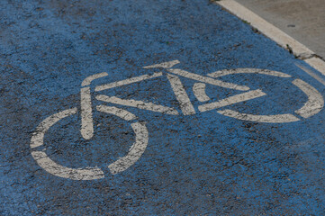 Bicycle lane marking on a vibrant blue pavement indicating safe space for cyclists in an urban...
