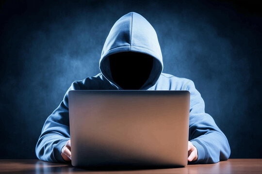 Shadow Hacker at Work: The silhouette of a hooded figure intensely focused on a laptop, bathed in an ominous blue glow, hints at digital intrigue.