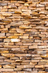 Sandstone wall detail in beige and brown tones, irregularly arranged, creating a rich and natural texture. Ideal for geology, construction, and design concepts