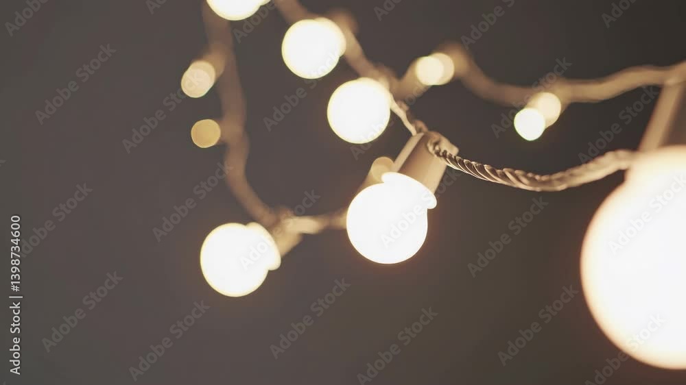 Poster soft-focus video of string lights against a dark background, captured from a low angle, creating a w