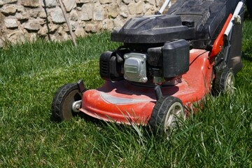 Obraz premium A lawn mower on a freshly mown lawn. The sharp contrast between the neatly trimmed surface and the untouched edges highlights the precise cutting ability of the lawn mower.