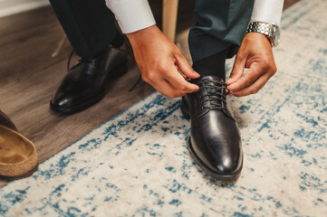 Groom tying dress shoes © Rikki Fletcher
