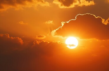 Dramatic sunset with vibrant orange colors, sun rays. Bright sun shines through clouds, creates beautiful scenic background. Orange sky, warm light illuminates clouds during sunrise. Nature, weather,